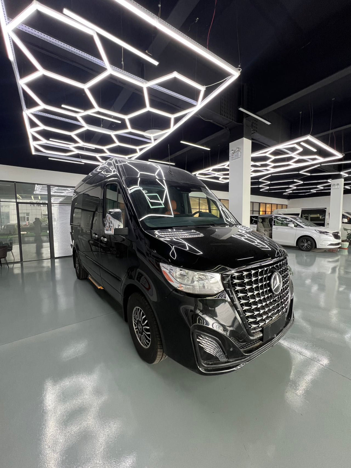 Toyota HiAce upgrade package: luxury seating, waterproof flooring, electric curtains, and a concealed bar/seating unit.