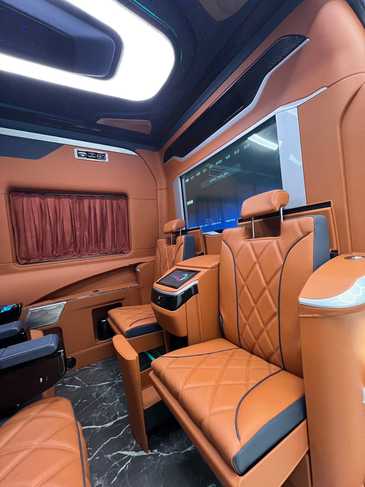 Toyota HiAce upgrade package: luxury seating, waterproof flooring, electric curtains, and a concealed bar/seating unit.